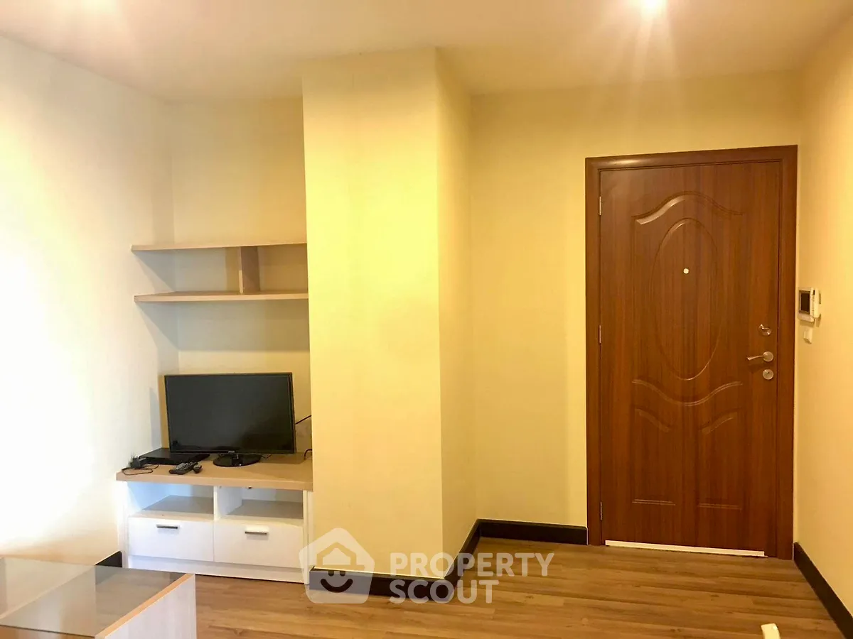 Cozy living room with modern TV setup and wooden flooring