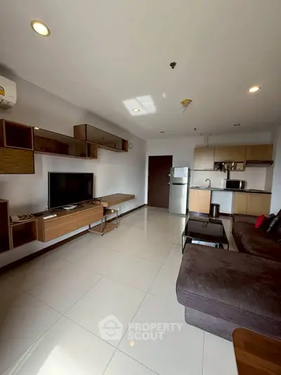 Modern living room with sleek furniture and open kitchen layout in a stylish apartment.