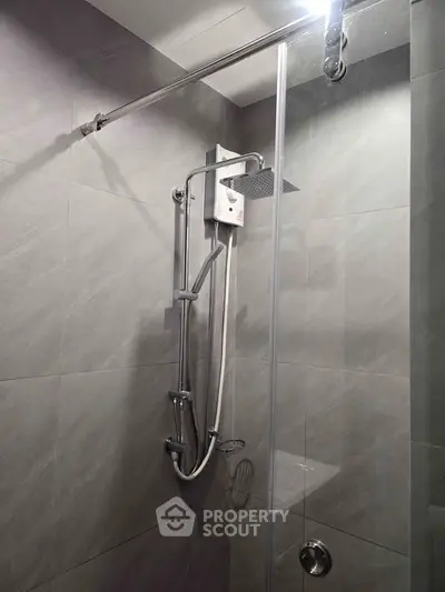 Modern bathroom with sleek shower design and elegant gray tiles.