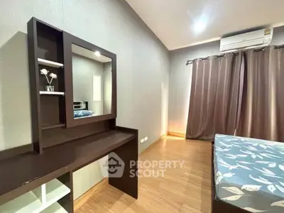 Spacious bedroom with modern decor and natural light, featuring a stylish vanity and comfortable bed.