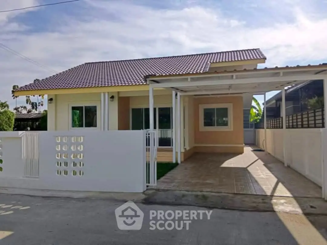 Charming single-story house with tiled roof and spacious carport in a serene neighborhood.