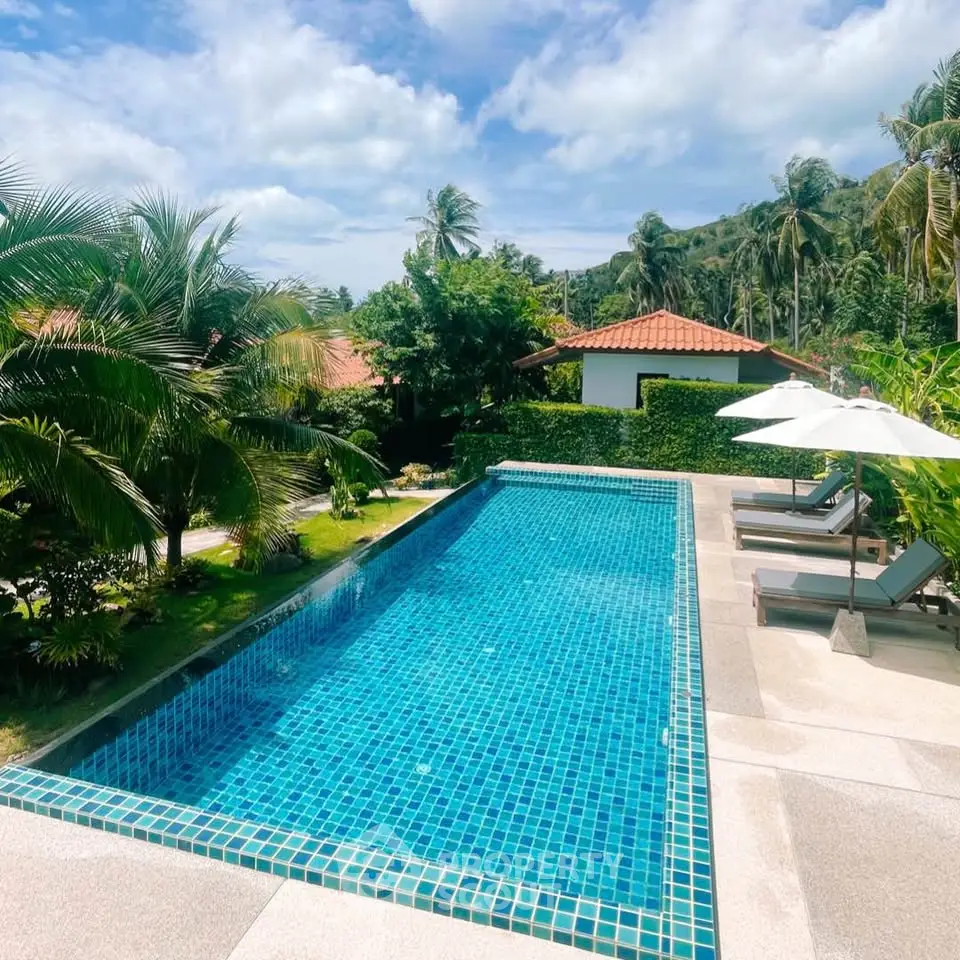 Luxurious tropical villa with stunning pool and lush garden views, perfect for relaxation and leisure.