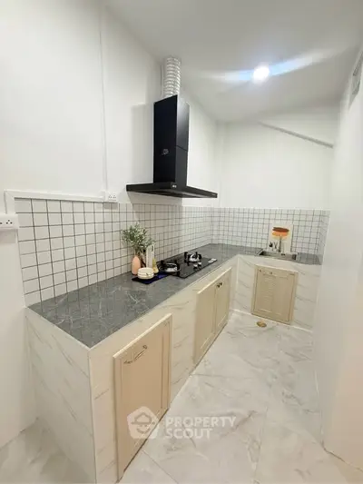 Modern kitchen with sleek design, featuring gas stove and stylish backsplash, perfect for culinary enthusiasts.