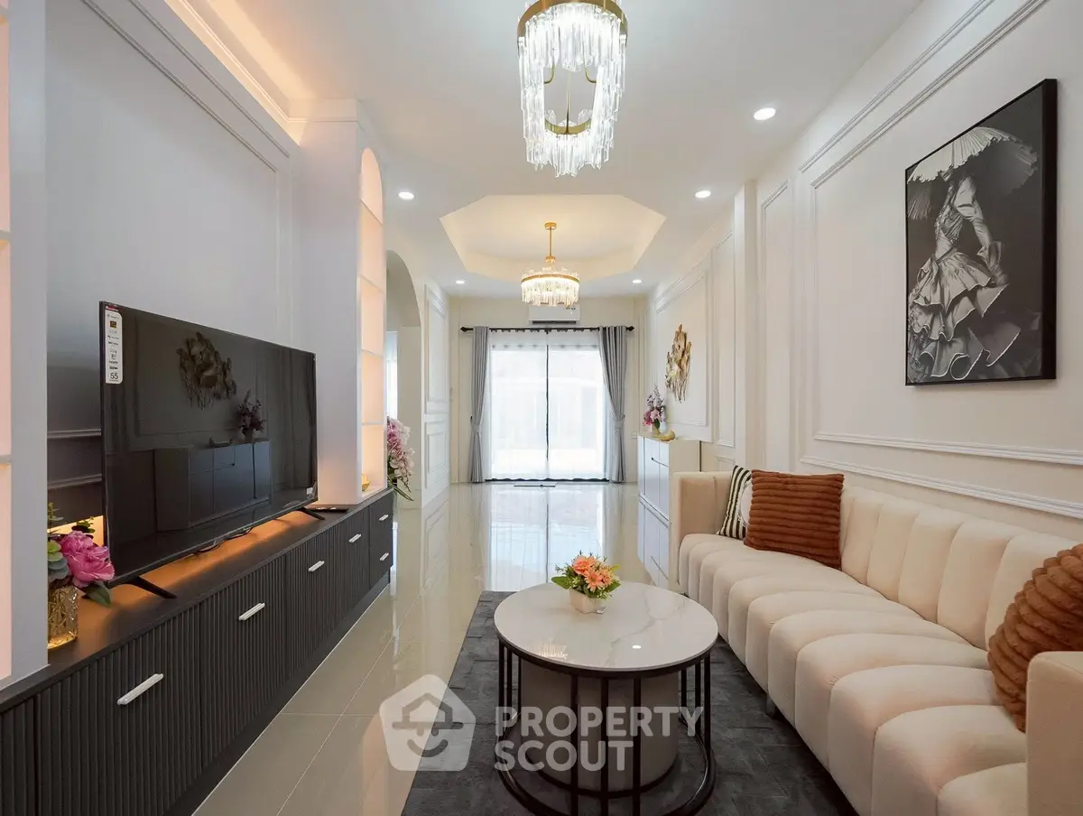 Luxurious living room with elegant decor, modern chandelier, and spacious layout.