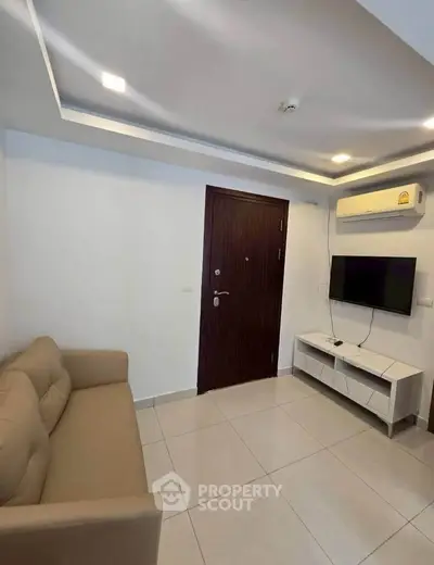 Modern living room with sleek design, featuring a cozy sofa and wall-mounted TV, perfect for relaxation.