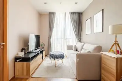 Cozy living room with modern decor and natural light, featuring a sleek TV stand and comfortable sofa.