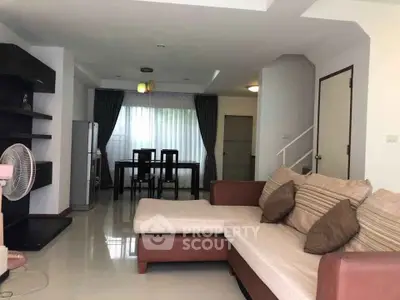 Spacious living room with modern sofa and dining area in open layout