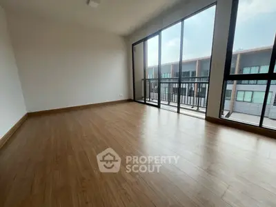 Spacious empty room with large windows and balcony access, perfect for customization.