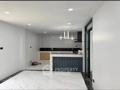 Modern open-plan kitchen with sleek design and marble flooring