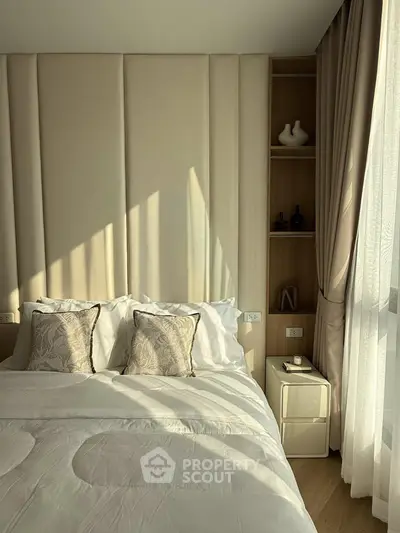 Luxurious bedroom with elegant decor and natural light, featuring plush bedding and stylish accents.