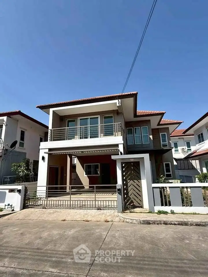 Modern two-story house with spacious balcony and contemporary design in a suburban neighborhood.