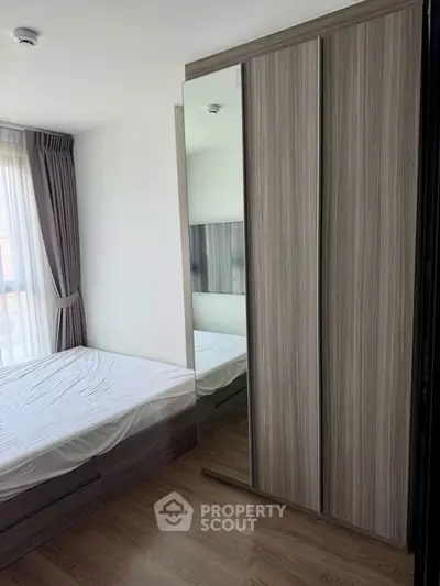 Modern bedroom with sleek wardrobe and large window for natural light