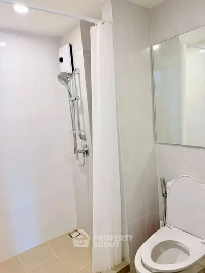 Modern bathroom with shower and toilet in sleek minimalist design.