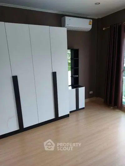 Spacious bedroom with modern wardrobe and air conditioning