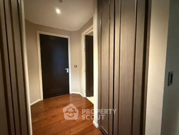 Elegant hallway with wooden flooring and modern doors in a stylish apartment.