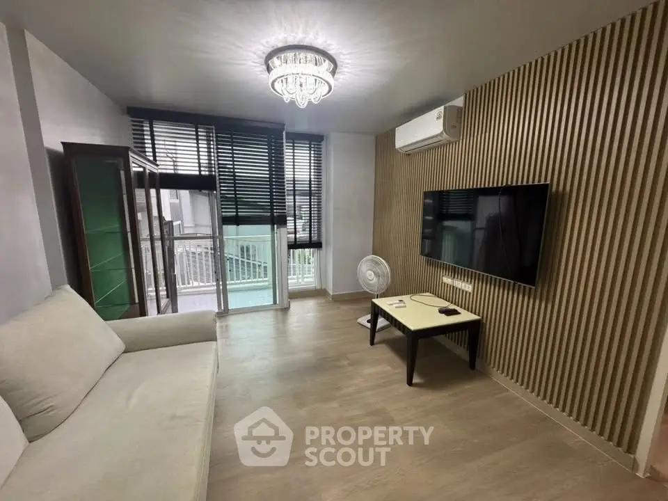 Modern living room with stylish decor, featuring a sleek TV setup and elegant lighting.