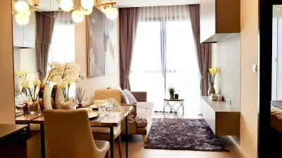 Elegant living room with modern decor, large window, and stylish dining area in a cozy apartment.