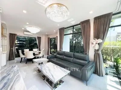 Luxurious living room with elegant decor and large windows offering natural light and garden view.