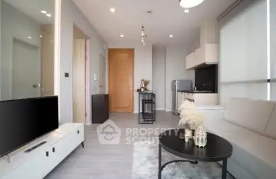 Modern living room with sleek furniture and open kitchen layout in a stylish apartment.