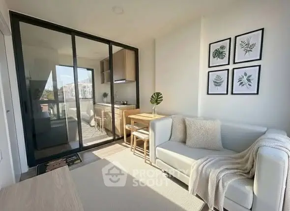 Modern living room with natural light, cozy sofa, and stylish decor adjacent to a compact kitchen.
