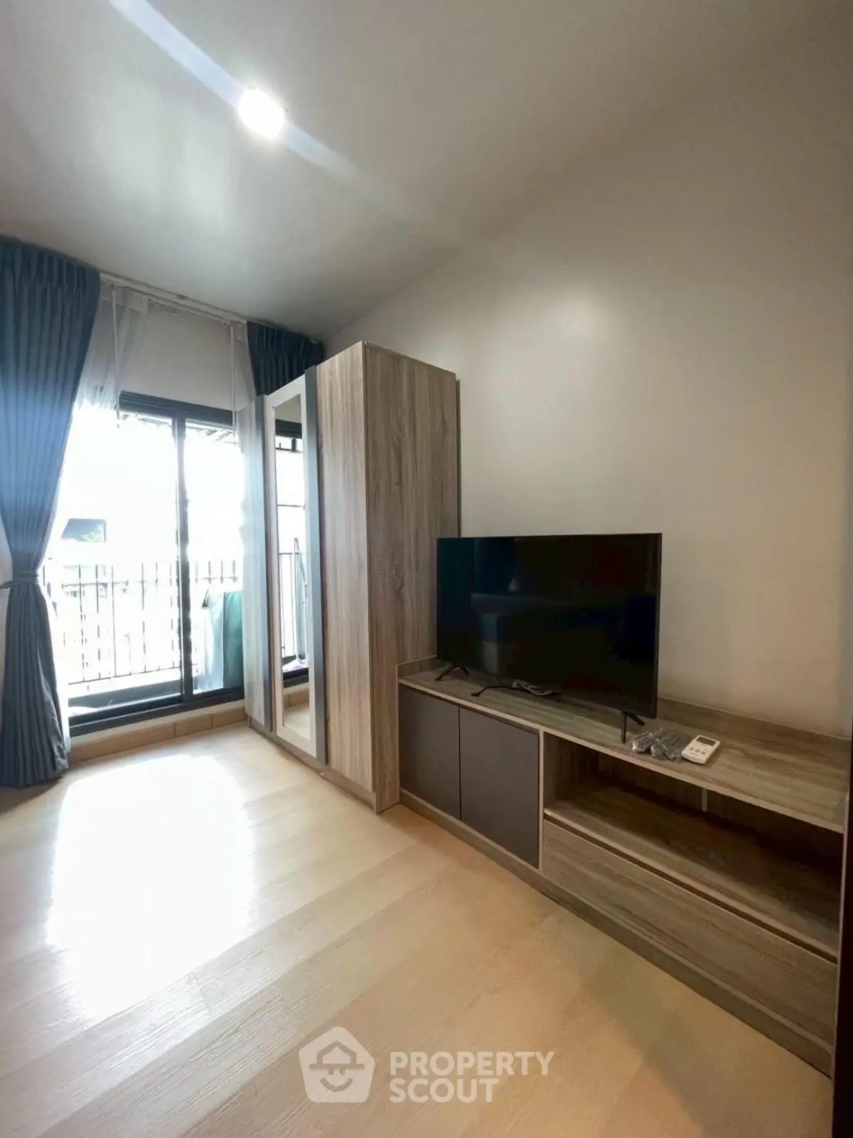 Modern living room with sleek TV stand and large window for natural light.