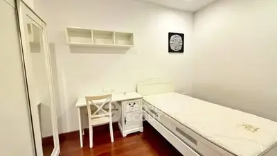 Cozy minimalist bedroom with white furniture and wooden flooring