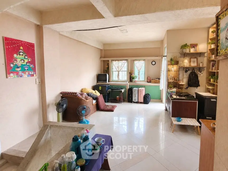 Spacious living room with natural light, cozy seating, and charming decor, perfect for relaxation and entertainment.