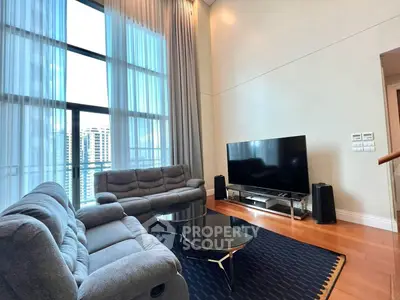 Spacious living room with high ceilings and modern furnishings in urban apartment.