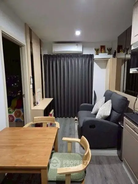 Cozy living room with modern furniture and dining area in compact apartment.