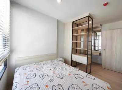 Modern bedroom with stylish shelving and natural light, perfect for a cozy living experience.