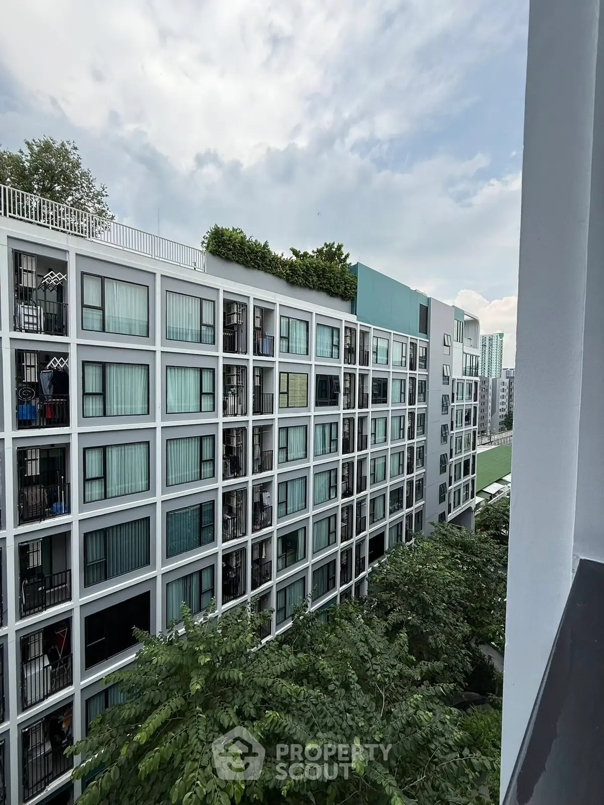Modern apartment building with lush greenery and rooftop garden view