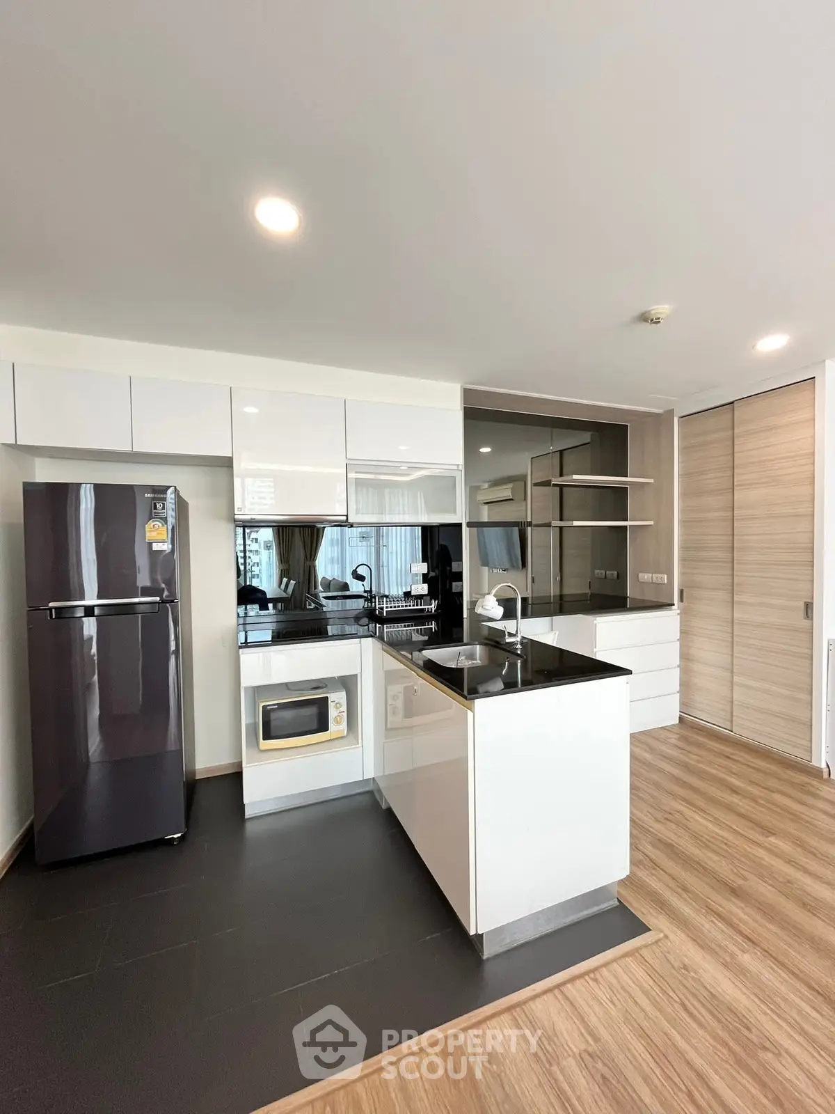 Modern kitchen with sleek design, featuring black countertops and stainless steel appliances.