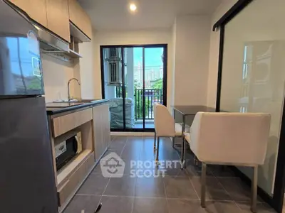 Modern kitchen with open layout and dining area, featuring sleek cabinetry and a view of the cityscape.