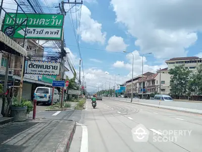 Charming street view with residential buildings and clear skies, ideal for urban living.