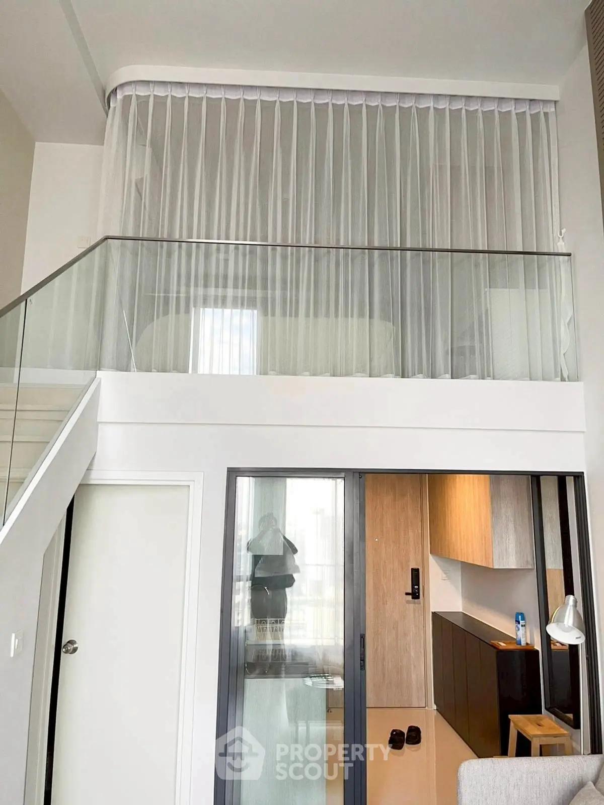 Modern duplex apartment with glass railing and sleek interior design