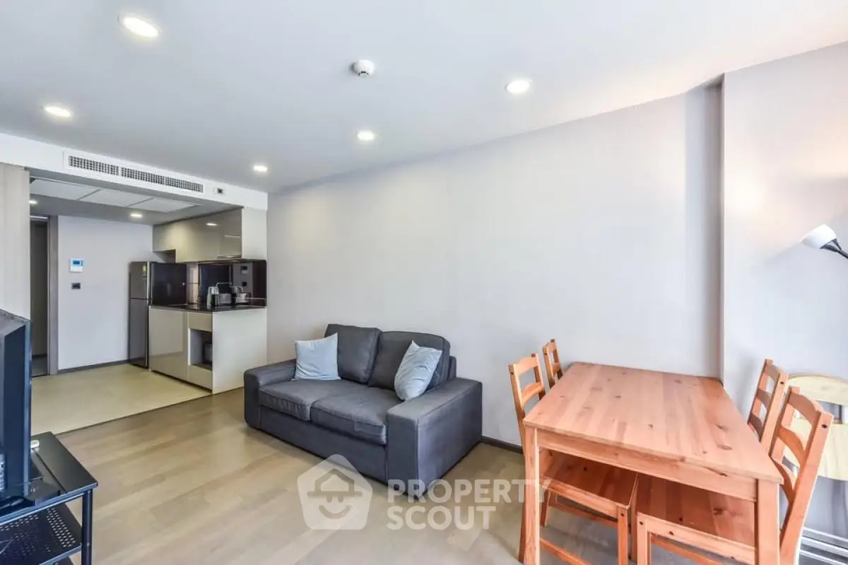 Modern living room with cozy sofa and dining area in open layout apartment.