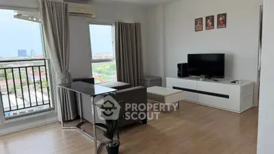 Modern living room with balcony view, sleek furniture, and natural light in a high-rise apartment.