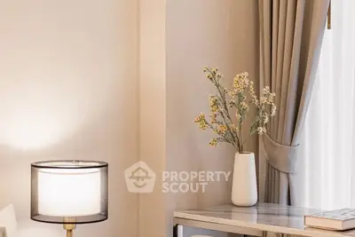 Elegant living room corner with stylish lamp and decorative vase on a sleek table.