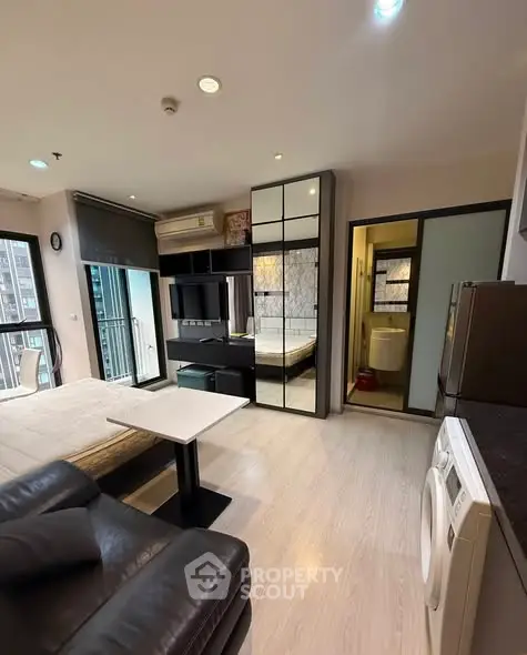 Modern studio apartment with sleek design, featuring a cozy living area, compact kitchen, and stylish bathroom.