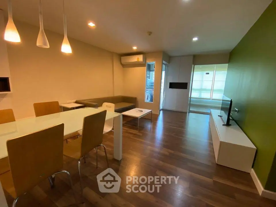 Modern living room with stylish furniture and open layout, featuring hardwood floors and ambient lighting.