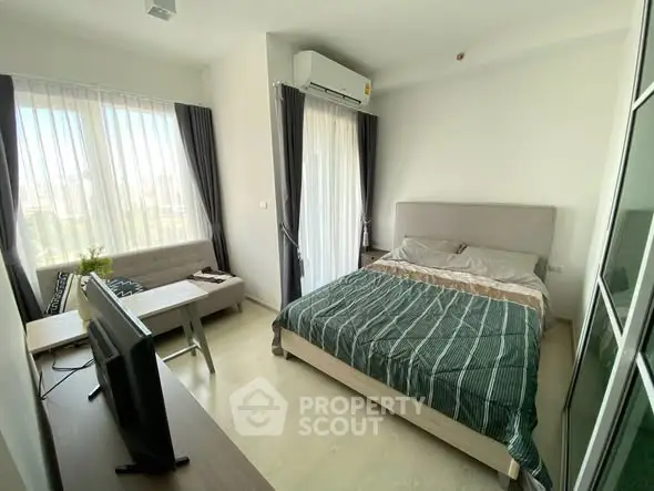 Modern bedroom with large windows, stylish decor, and natural light in a contemporary apartment.
