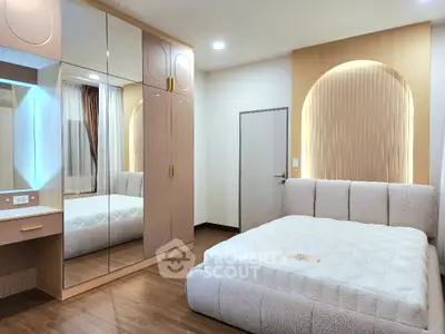 Modern bedroom with stylish mirrored wardrobe and cozy bed