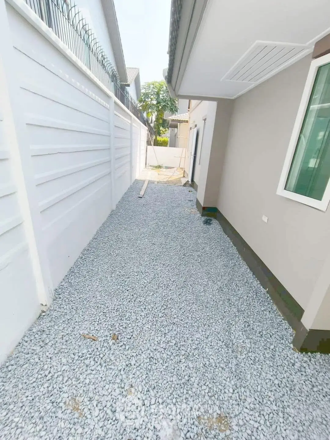 Spacious side yard with gravel path beside modern house exterior