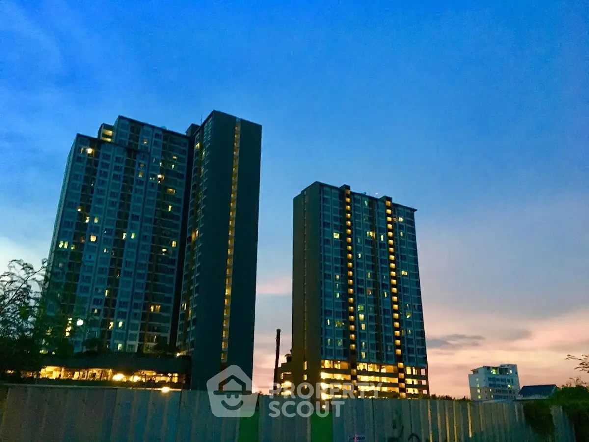 Stunning high-rise apartment buildings at dusk with illuminated windows and vibrant sky.