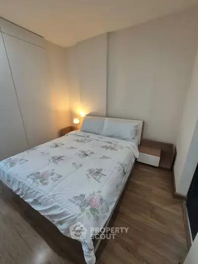 Cozy bedroom with wooden flooring and modern furniture, perfect for relaxation.