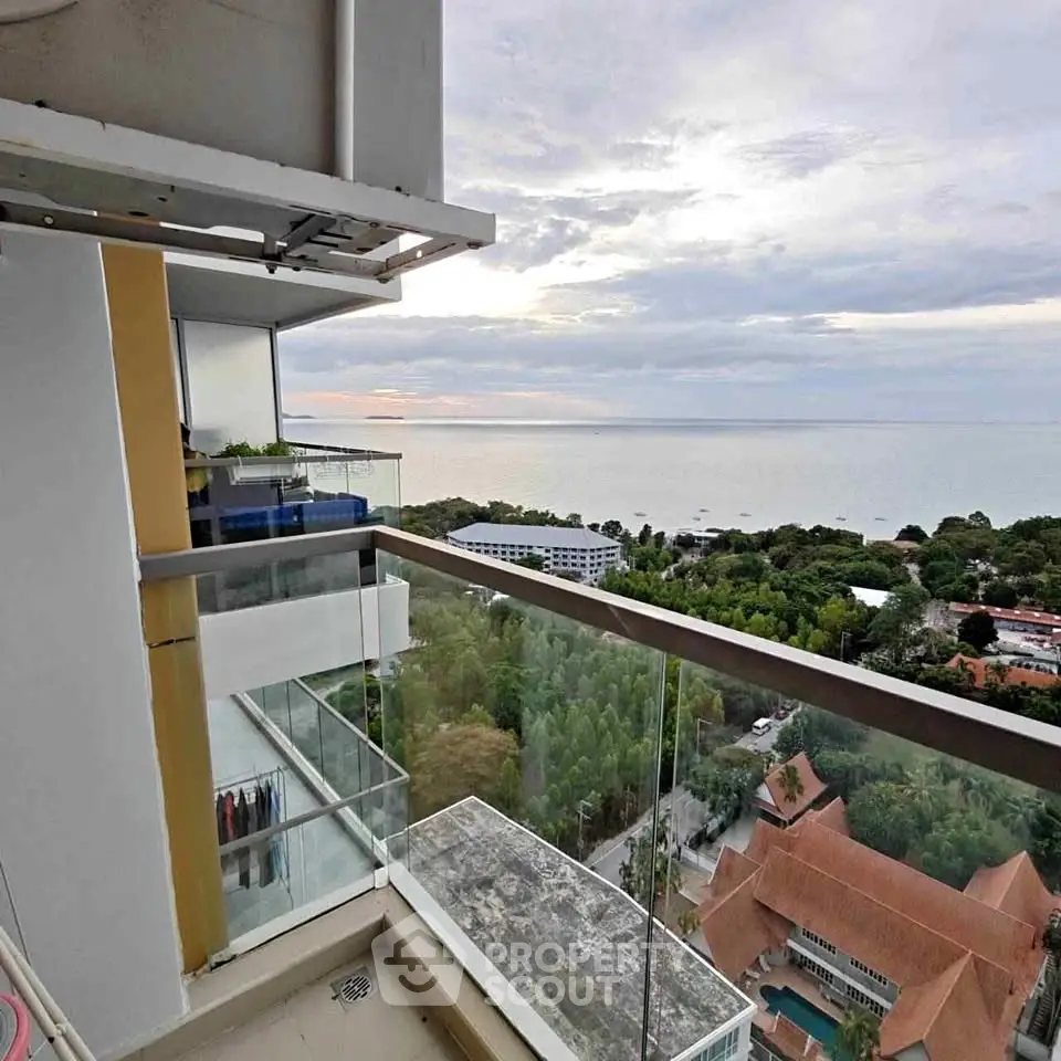 Stunning balcony view overlooking lush greenery and ocean horizon, perfect for serene living.