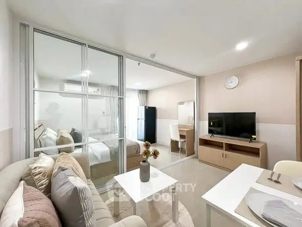 Modern living room with glass partition, cozy sofa, and sleek TV setup in a stylish apartment.