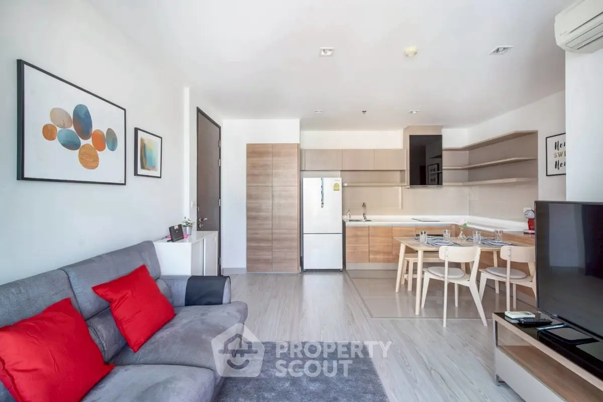 Modern open-plan living room with kitchen, stylish decor, and cozy seating area.