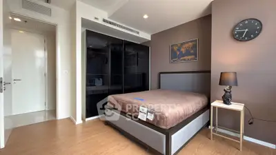 Modern bedroom with sleek black wardrobe and stylish decor in a contemporary apartment.