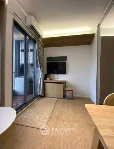 Modern living room with sleek TV setup and balcony access